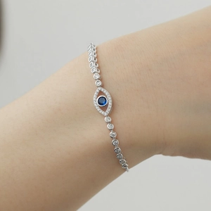 Macro shot of silver evil eye bracelet with blue gemstone and shimmering crystal links
