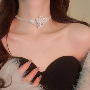 Close-up of white crystal flower choker necklace showing elegant bead details and mesh texture