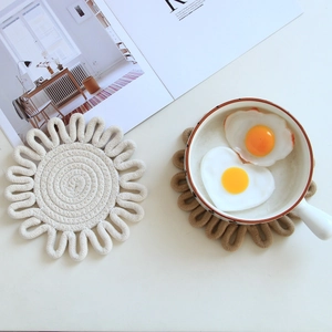 Macro detail of hand-woven cotton petal-shaped placemats in cream and khaki brown
