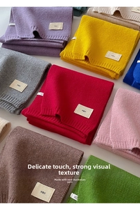 Close-up of colorful knitted scarves in various shades showing fine texture and emo label