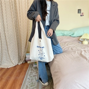 Détail d'un sac cabas en toile blanche avec lapin astronaute bleu et imprimé LOVABE