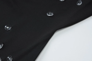 Gros plan sur une robe noire en maille avec des perles scintillantes en forme de gouttes