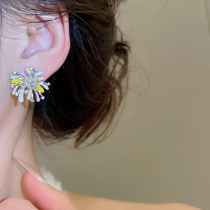Close-up of floral stud earring with colorful enamel petals and sparkling small diamonds