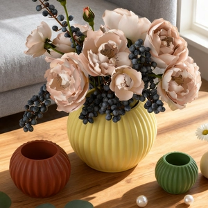 Detailed view of textured round resin candle holders in yellow, red and green tones