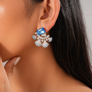 Detail of luxury fan-shaped earring with blue rectangular stone and sparkling diamonds