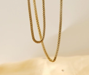 Detail of 18K gold-plated stainless steel mesh chain with hollow design and polished finish