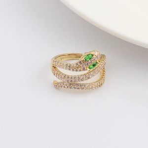 Dettaglio dell'anello a serpente dorato con occhi di gemma verde e pavé di zirconi