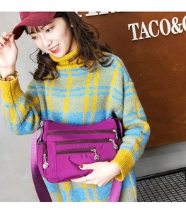 Detail view of the purple waterproof Oxford cloth crossbody bag with silver zippers