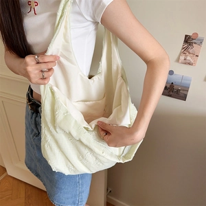 Detailaufnahme der Blumenstickerei auf einer weichen Stoff-Schultertasche für Damen
