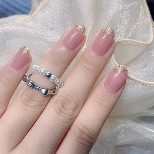Flesh pink French press-on nails with elegant gold foil accents and pearl ring styling