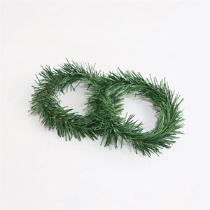 Detailed view of two green PVC pine needle candle rings with realistic texture and shape