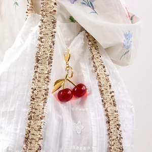 Detaillierte Nahaufnahme des Kirsch-Taschenanhängers mit roten Harzfrüchten und Goldlaub