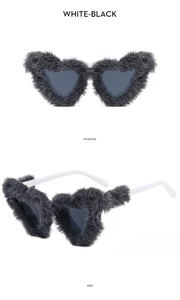 Macro view of plush heart-shaped sunglasses in black grey fur with white arms