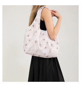 Detailed back view of a floral tote bag with wide straps on a model in black outfit