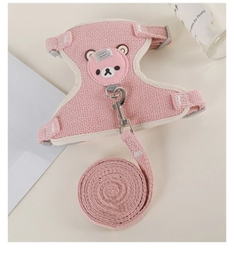Pink textured pet harness and leash set with metal hook and buckle on minimalist background