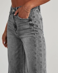 Détail du tissu denim gris délavé et double surpiqûre sur un pantalon large