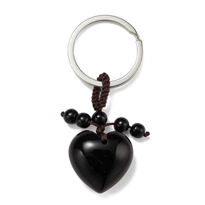 Macro view of polished heart-shaped black stone keychain with woven beads detail