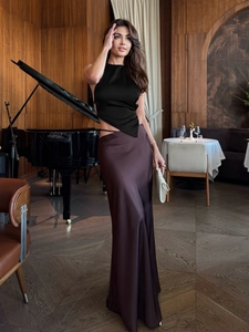 Détail d'un haut dos nu noir élégant et d'une jupe longue en satin dans un intérieur chic