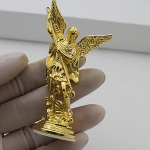 Close-up of golden Michael angel statue with intricate wing and armor details
