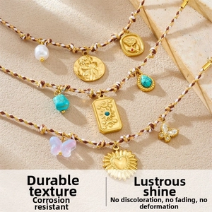 Macro detail of bohemian braided bracelet with vintage gold floral and butterfly charms