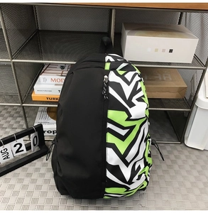 Detail of color-block backpack with front zipper and side drawstring in study setting