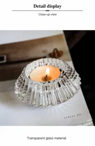 Close-up of ribbed glass candle holder with tea light candle and warm light reflection