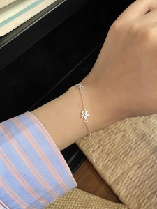 Detailed view of S925 sterling silver flower bracelet with lobster clasp on a woman's wrist