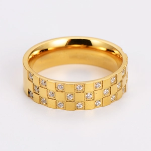 Macro shot of gold stainless steel checkerboard ring featuring inlaid rows of zircon stones