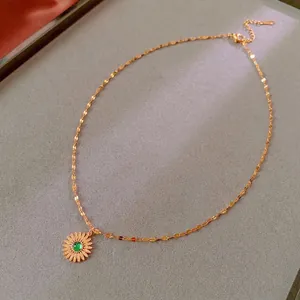 Vintage golden sunflower necklace with a green gemstone pendant on a polished chain