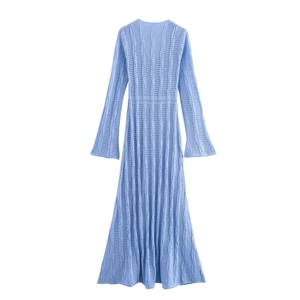 Détail de la robe en maille bleu clair montrant la texture ajourée et les manches évasées