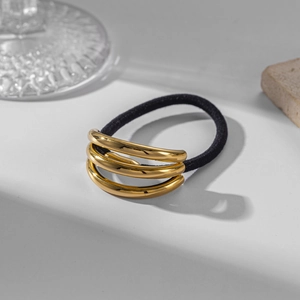 Close-up of golden multi-ring elastic hair tie with professional still life styling