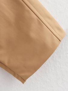 Macro shot of khaki woven fabric showcasing fine stitching on a bomber jacket detail