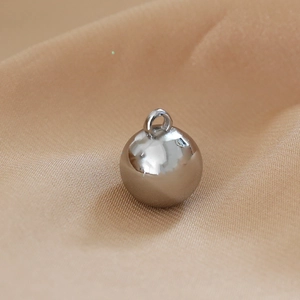 Macro detail of a polished silver metal spherical pendant with ring for DIY jewelry making