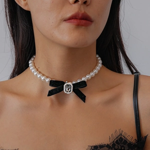 Close-up of black velvet bow and crystal pendant on elegant faux pearl choker