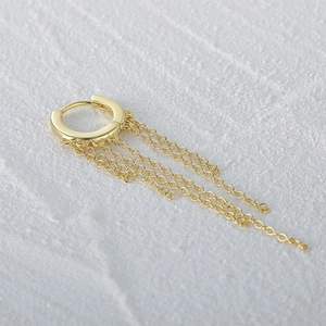 Macro shot of gold S925 sterling silver hoop earrings with multi-layered tassel chains
