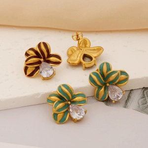Détail macro de boucles d'oreilles fleurs avec pétales en émail et zircons en forme de goutte