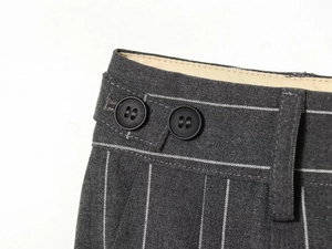 Détail de la taille du pantalon de costume rayé gris foncé avec boutons noirs et doublure