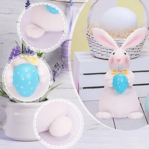 Detail shots of plush pink Easter bunny holding a polka dot egg on white wood background