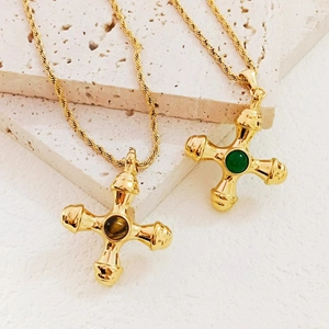 Vintage gold cross pendant necklace featuring tiger eye stone on travertine background