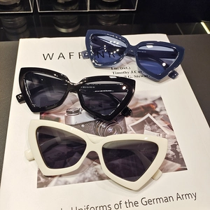 Vintage cat-eye triangle sunglasses in navy, black and white on a fashion magazine