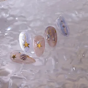 Macro detail of blue and pink embossed 3D nail stickers with golden stars and shells