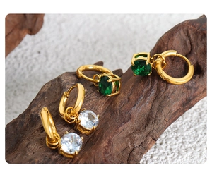 Dettaglio di orecchini vintage in titanio dorato con pietre di zirconia cubica scintillanti