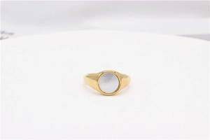 Detailed close-up of golden signet ring featuring a round white mother of pearl inlay