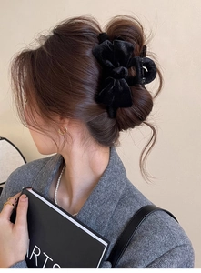 Elegant large black velvet bow hair claw clip styled on a model in a sophisticated updo