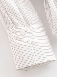 Close-up of white striped shirt cuff with two buttons and precise stitching details
