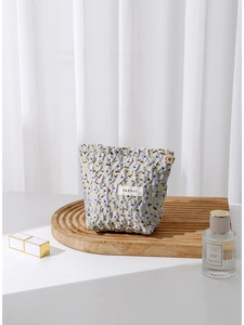 Floral jacquard cosmetic bag with purple and green patterns on a wooden tray
