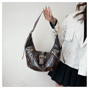 Detail of dark brown hobo bag featuring vintage studs and golden buckle accents