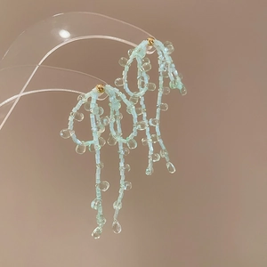 Pendientes de lazo con cuentas azul claro con borlas y detalles dorados hechos a mano