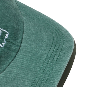 Detailed macro view of dark green baseball cap brim featuring multi-row reinforcement stitching