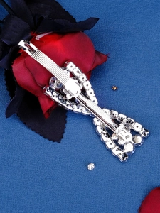 Close-up of silver crystal bow hair clip on dark background with decorative roses